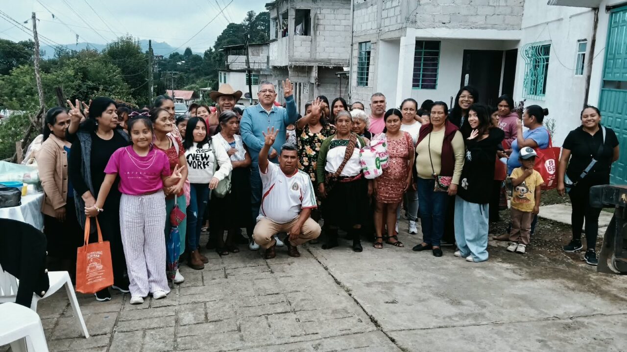 Vecinas y vecinos se reúnen en una calle de Huauchinango para un encuentro comunitario.