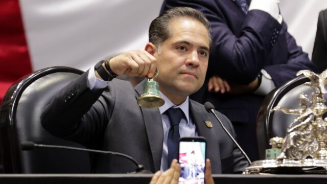 Legislador sostiene una campana durante una sesión en la Cámara de Diputados.